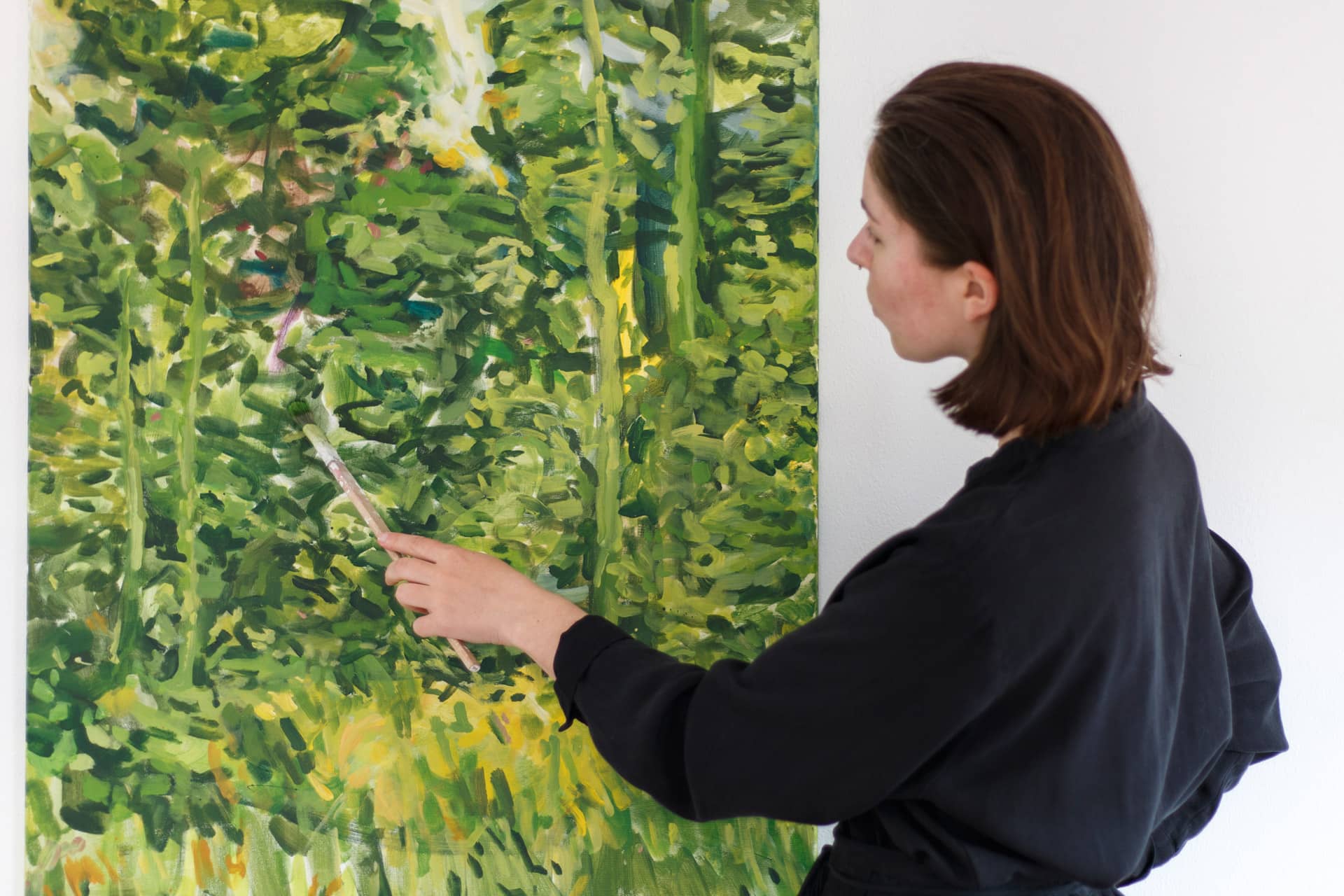Die Künstlerin Anja Dommel arbeitet an einem grünen, großformatigen Gemälde, von den Wäldern bei Nürnberg inspiriert